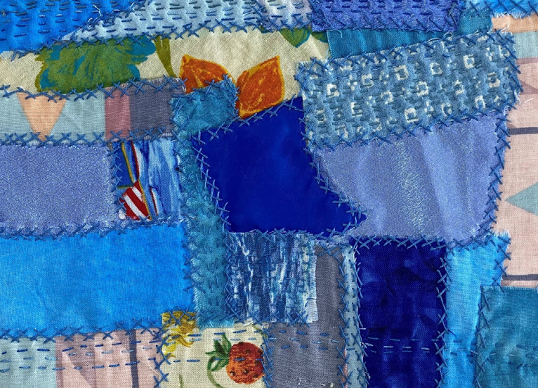 Image of textile work featuring blue fabrics and stitching