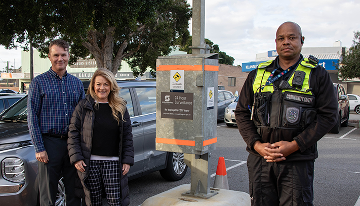 Community safety officer standing beside a CCTV surveillance camera unit with Lawley Ward Councillors in a carpark.