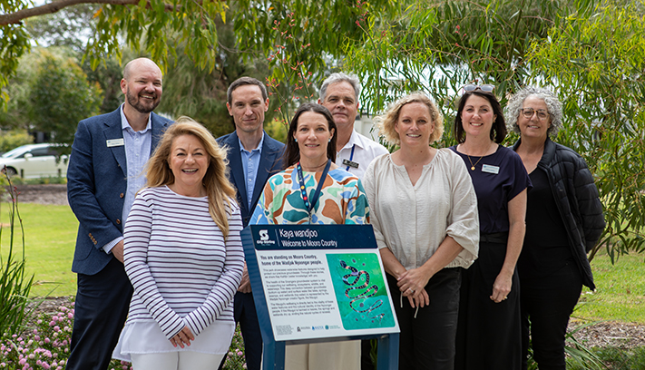 Representatives from the City of Stirling, DWER and Water Corporation in front of interpretive signage at a park.