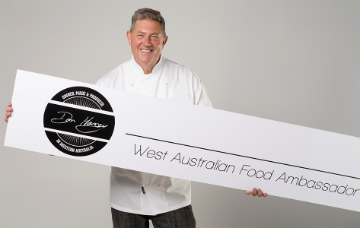 The Kitchen Osborne Park founder Don Hancey holding a branded sign.