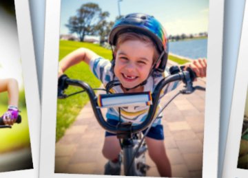 Image of a child on a bike on a bike path smiling at the camera