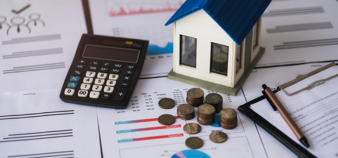 A pile of coins, papers and a model house