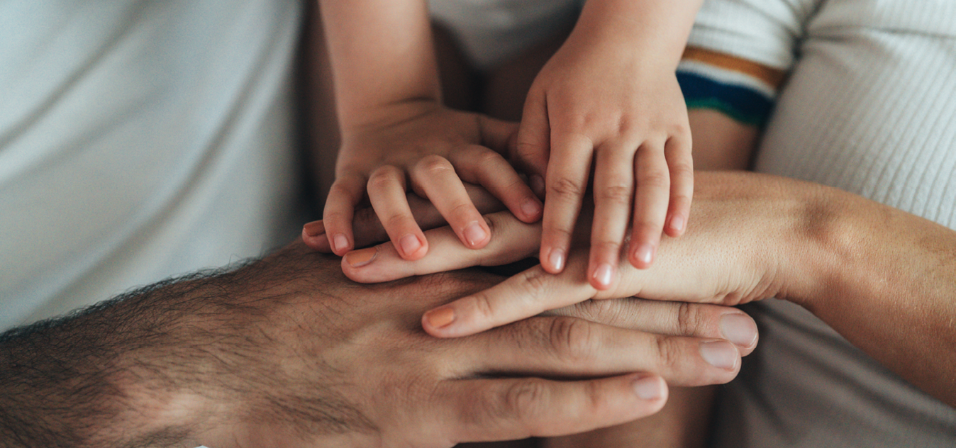 A family of three holding hands