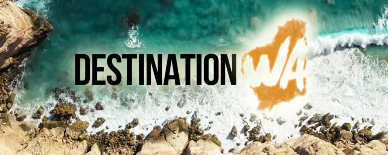 Aerial view of waves crashing onto a rocky coastline, overlaid with the text “Destination WA”.